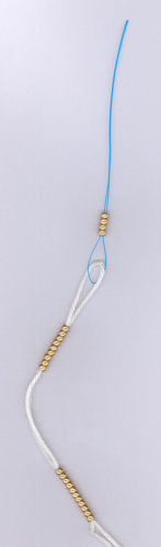 Stringing beads using a nylon floss threader Stringing beads using a nylon floss threader